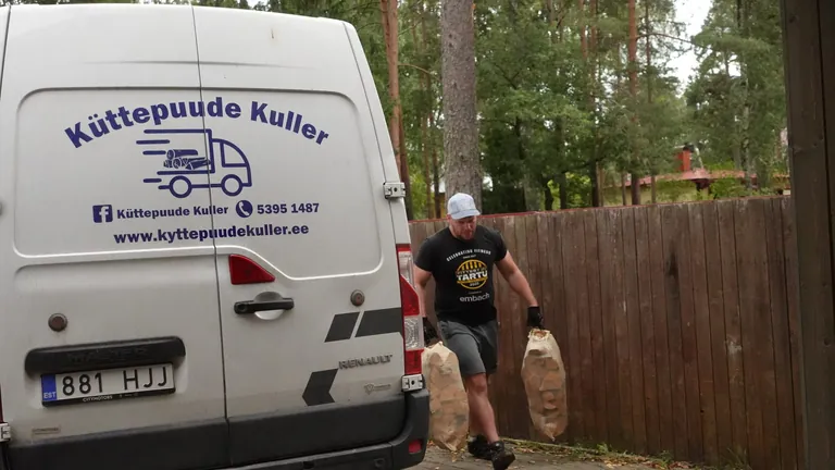 Küttepuude Kulleri kaubik tagantvaates, kuller toob kotte hoovi