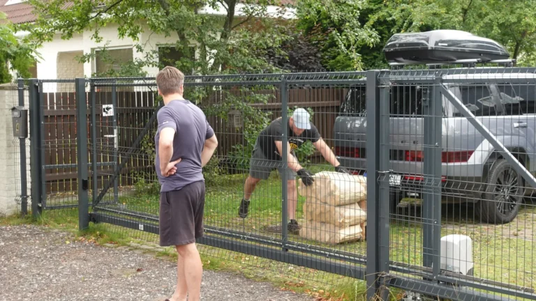 Küttepuud võrkkottides tuuakse eramaja hoovi, klient jälgib väravalt